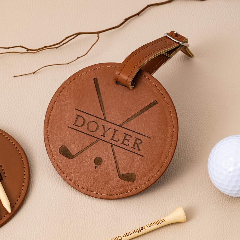 May include: Brown leather golf bag tag with a personalized name "DOYLER" and a design of crossed golf clubs.