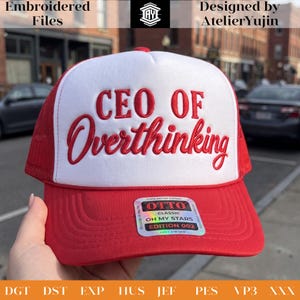 May include: A red and white trucker hat featuring the embroidered red text CEO OF Overthinking on the front panel. The hat includes a red mesh back, a red brim, and a holographic sticker on the brim that reads OTTO CLASSIC OH MY STARS EDITION 002.