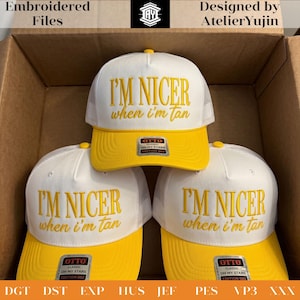 May include: White and yellow baseball caps with the embroidered text "I'M NICER when I'm tan." The caps have a mesh back and a curved brim. The caps are from the "OH MY STARS EDITION 002" collection.