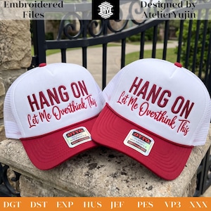 May include: Two white and red trucker hats featuring white mesh back panels and solid red brims. The front panels display the embroidered text HANG ON Let Me Overthink This in bold red lettering. Each hat includes an Otto Classic sticker on the brim.