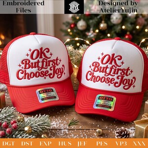 May include: Two red and white trucker hats featuring the embroidered red text OK But first Choose Joy with small star accents. Each hat has a red mesh back, a white front panel, and a red brim with an Otto Classic Mid Profile sticker attached.