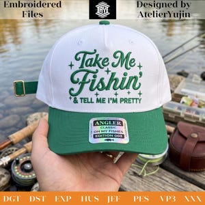 May include: A white baseball cap with a green brim and green embroidered text that reads Take Me Fishin' & TELL ME I'M PRETTY. The cap features a green adjustable strap with a gold-toned metal buckle and a holographic sticker on the brim.