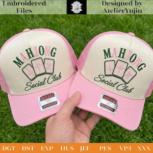 Peut inclure: Deux casquettes roses avec un panneau avant crème. Les casquettes sont brodées des mots "MAHJONG Social Club" et de trois tuiles de Mahjong vertes. Les casquettes ont un dos en filet rose et une visière incurvée.
