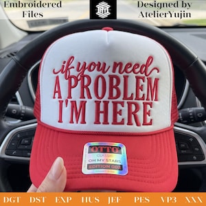 以下が含まれることがあります： フロントのフォームパネルに赤い刺繍で「if you need A PROBLEM I'M HERE」と書かれた赤と白のトラッカーキャップ。キャップには装飾ステッチが施された赤いバイザーと、「OTTO CLASSIC OH MY STARS EDITION 002」と書かれたホログラムステッカーが前面に貼られています。