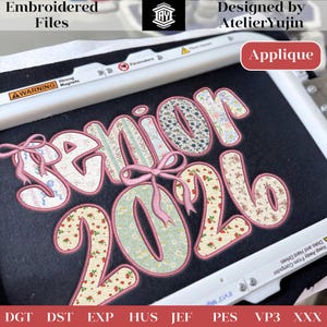 Puede incluir: Un diseño bordado con el texto "Senior 2026" en fuente de burbujas, decorado con patrones florales y lazos rosas. El diseño está etiquetado como "Applique" e incluye el texto "Embroidered Files" y "Designed by AtelierYujin".