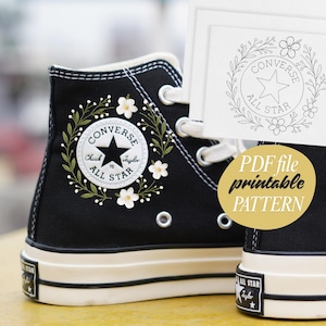 May include: Black Converse All Star high-top trainers with white laces and soles. The trainers feature a floral design around the Converse All Star logo. A PDF file with a printable pattern is also visible.