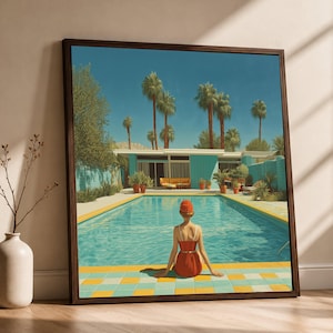 Könnte beinhalten: Ein gerahmter Kunstdruck, der eine Person in einem roten Badeanzug mit passender Badekappe am Rand eines türkisfarbenen Swimmingpools zeigt. Die Szene umfasst ein modernes Haus mit blauen Wänden, hohen Palmen und einer gelb-blau gefliesten Terrasse.