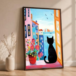 May include: A framed painting depicting a black cat sitting on a windowsill looking out at a coastal city scene with colourful buildings, a blue sea, and a pot of pink flowers in the foreground under a light blue sky with three small birds.