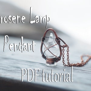 May include: A copper wire pendant shaped like a kerosene lamp with a glass vial and a chain. The pendant is on a wooden surface with the text "Kerosene Lamp Pendant PDF tutorial" above it.