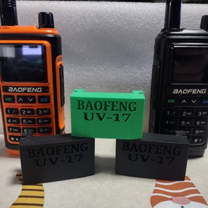 May include: Two black and one orange handheld radios with black and green labels that say "BAOFENG UV-17".