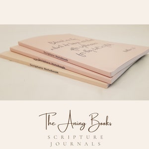 May include: Three pink Scripture Notebooks stacked on top of each other. The top notebook has the text "Blessed are the peacemakers, for they shall be called the children of God."  The notebooks are labelled "Scripture Notebook".