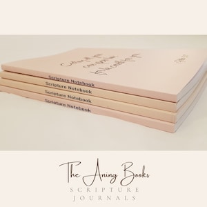 May include: A stack of four pink Scripture Notebooks with the text "Choose joy, it can carry you through the darkest of times." and "Peter 1:2" on the top notebook. The text "The Anning Books Scripture Journals" is printed below the stack of notebooks.