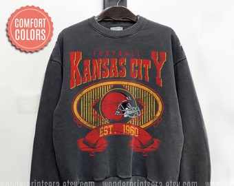 Könnte beinhalten: Ein dunkelgrauer Pullover mit einer Grafik im Vintage-Stil eines Footballhelms und dem Text "FOOTBALL KANSAS CITY EST. 1960".