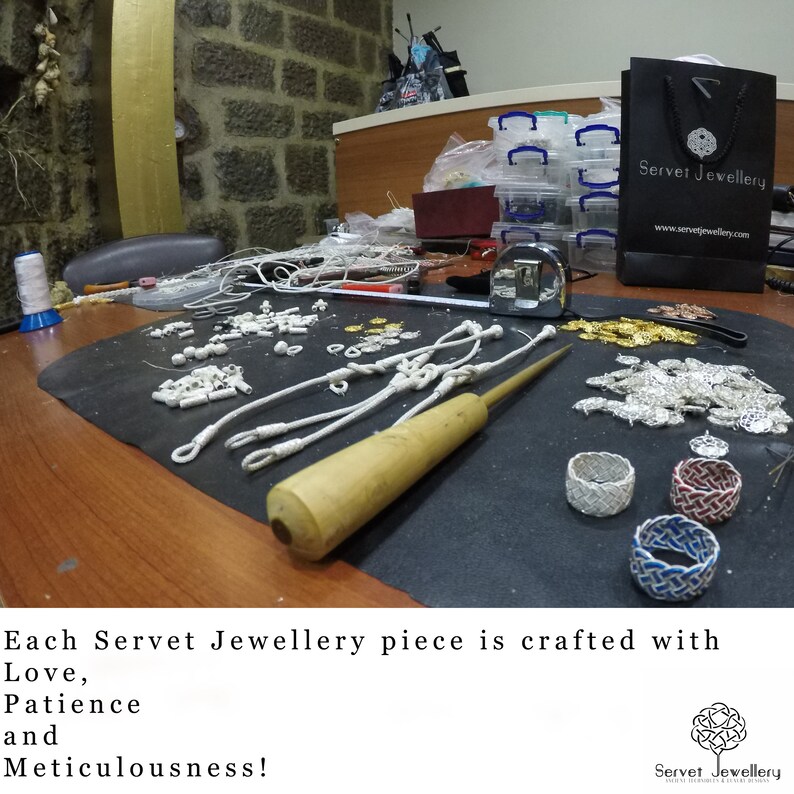 May include: A close-up of a workbench with various jewelry making supplies, including silver beads, white string, and a wooden tool. The text "Servet Jewellery" is visible on a black bag in the background. The caption reads "Each Servet Jewellery piece is crafted with Love, Patience and Meticulousness!"