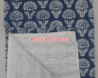 Könnte beinhalten: Eine weiße und blaue Kantha-Steppdecke mit einem Blumenmuster. Die Decke ist in der Hälfte gefaltet und die Innenseite ist weiß mit einem dezenten Blumenmuster. Die Decke ist mit "Keeva Traders" beschriftet.