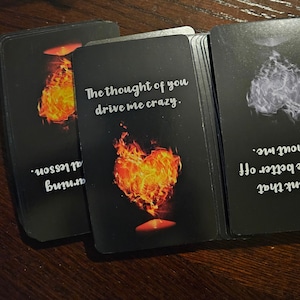Könnte beinhalten: Zwei schwarze Karten mit weißem Text und Bildern. Die erste Karte hat eine herzförmige Flamme mit dem Text "The thought of you drive me crazy." Die zweite Karte hat eine weiße Wolke mit dem Text "Think that are better off without me."