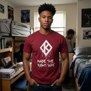 May include: A maroon short-sleeve t-shirt featuring a white diamond-shaped logo with a dripping paint effect and the text "MADE THE RIGHT WAY" printed in white lettering below the graphic on the front of the garment.