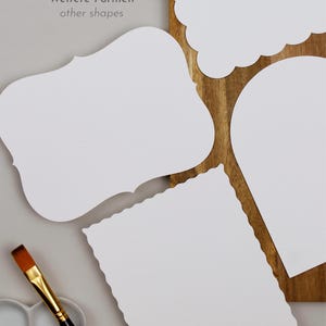 May include: Four blank white paper shapes with scalloped edges. The shapes are a rectangle, a square, a cloud, and a teardrop. The shapes are on a wooden surface. The text "Weitere Formen" and "other shapes" is written in gray text on a light gray background.