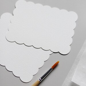Einzelne Aquarellkarten neben einem Holzpinsel
