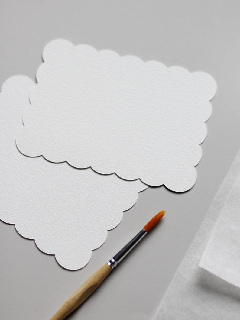 Einzelne Aquarellkarten neben einem Holzpinsel