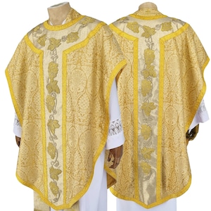 May include: A gold liturgical chasuble with a vine pattern embroidered in silver thread. The chasuble has a pointed front and back, and a wide collar.