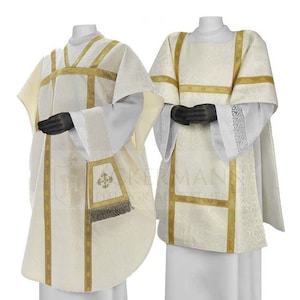 May include: Two white liturgical vestments with gold trim. The vestment on the left has a matching stole with a gold embroidered cross. The vestment on the right has a matching chasuble.