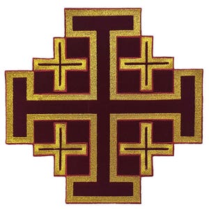 May include: A burgundy patch featuring a Jerusalem cross design. The cross is outlined in gold thread, with smaller crosses at each corner. The design is symmetrical and centered, with a detailed embroidered appearance.