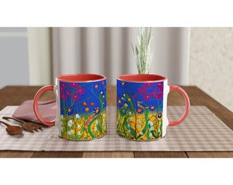 Op de afbeelding: Twee witte keramische mokken met rode randen. Beide mokken hebben een kleurrijk bloemenontwerp met blauwe, groene, gele, roze en oranje bloemen op een blauwe achtergrond.