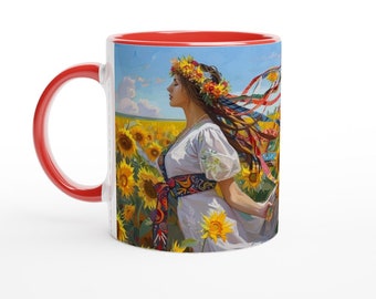 Op de afbeelding: Een rode en witte koffiemok met een kleurrijk beeld van een vrouw in een zonnebloemenveld. De vrouw draagt een witte jurk met een kleurrijke band en een bloemenkrans. Haar haar waait in de wind.