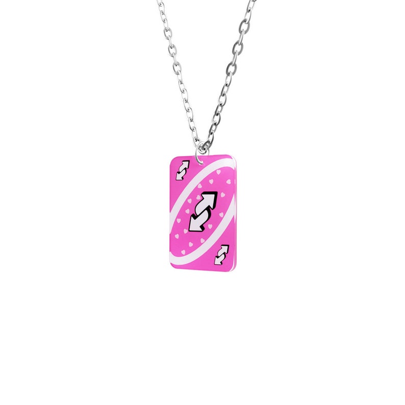 May include: A silver chain necklace with a pink Uno card pendant featuring a white reverse card symbol and white hearts.