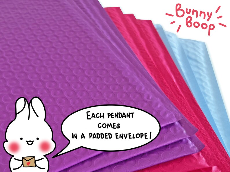 May include: A stack of colorful bubble mailers, with the top one purple, the next pink, then light blue. The text "Each pendant comes in a padded envelope!" is written in a speech bubble with a cartoon bunny holding a small envelope.