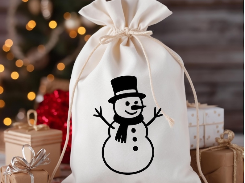 May include: A cream-colored drawstring gift bag featuring a black snowman design. The snowman has a top hat, scarf, and stick arms. The bag is tied at the top with a matching drawstring, perfect for holiday gifting.