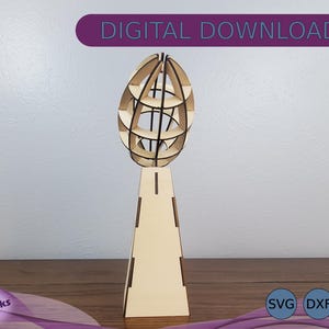 May include: A wooden model of a globe on a stand. The globe is made of multiple layers of wood, creating a 3D effect. The stand is a simple, rectangular shape. The model is a digital download, available in SVG, DXF, and EPS formats.