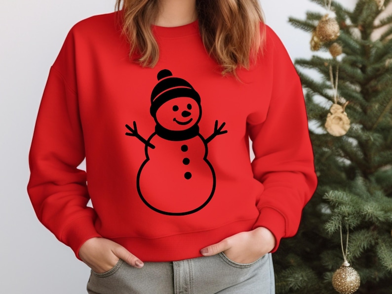 May include: A red sweatshirt featuring a black snowman graphic. The snowman has a black hat, scarf, and three buttons. The sweatshirt is a solid red color, perfect for the holiday season.