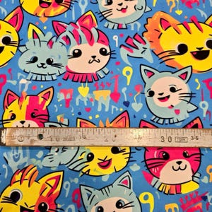 Tela de gato kawaii - Estampado de caras de gatitos de colores - Fondo azul divertido - Gatos de dibujos animados felices - Patrón de mascota divertido y caprichoso - Arte brillante