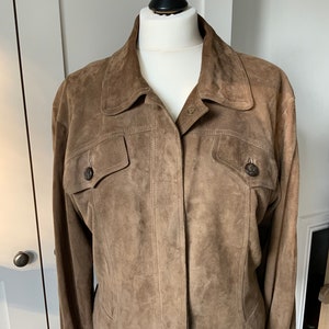 K&ouml;nnte beinhalten: Eine braune Wildlederjacke mit Knopfleiste und zwei Pattentaschen.
