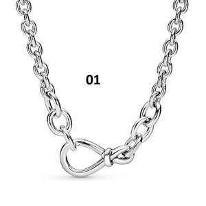 May include: A silver chain necklace with a unique infinity knot design. The chain is made of linked oval shapes.