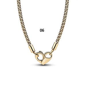 May include: A gold chain necklace with a heart-shaped clasp. The chain is made of small, linked squares. The number 06 is printed on a white background.