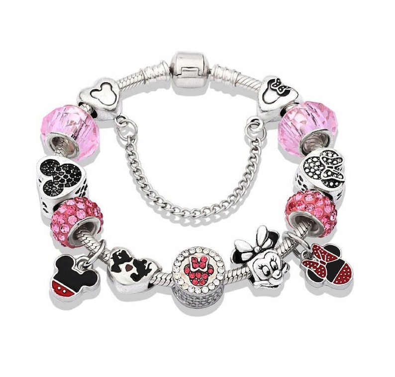 Pu&ograve; includere: Un braccialetto con ciondoli in argento con ciondoli di cristallo rosa e rosso, con i personaggi di Topolino e Minnie Mouse.