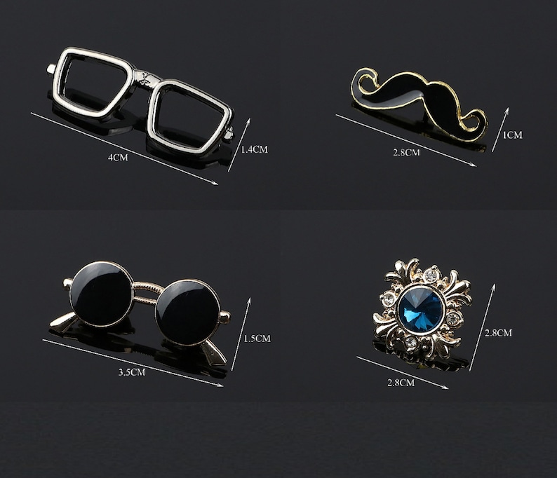 K&ouml;nnte beinhalten: Vier verschiedene Anstecknadeln, jede mit einem anderen Design. Die erste Nadel ist eine silberfarbene Brille, die zweite ist ein goldfarbener Schnurrbart, die dritte ist eine schwarze Sonnenbrille und die vierte ist eine goldfarbene Nadel mit einem blauen Edelstein in der Mitte.