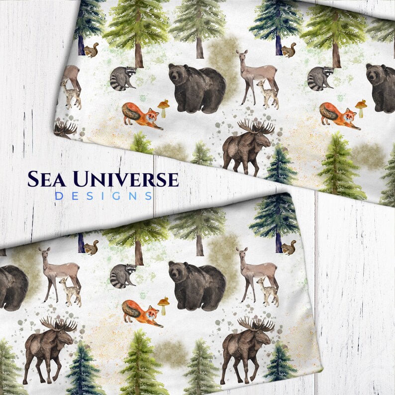 May include: A white fabric with a repeating pattern of woodland animals and trees. The animals include a moose, bear, deer, raccoon, and fox. The trees are green and brown. The fabric has a watercolor effect.