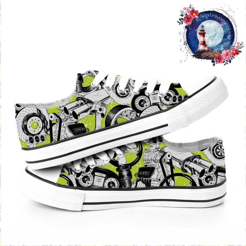 May include: A pair of white canvas shoes with a green background and a black and white print of car parts. The shoes have white laces and a black trim.