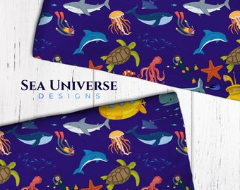 May include: Sea life pattern fabric featuring a yellow submarine, blue whales, sharks, jellyfish, starfish, sea turtles, and divers on a dark blue background. The fabric is labeled "Sea Universe Designs".