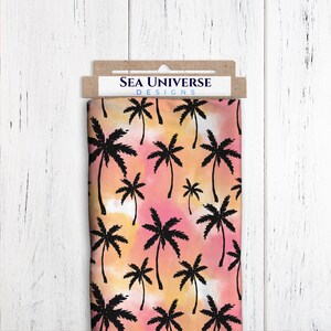 May include: A fabric swatch with a repeating pattern of black palm trees on a pink and orange watercolor background. The fabric is labeled "Sea Universe Designs".