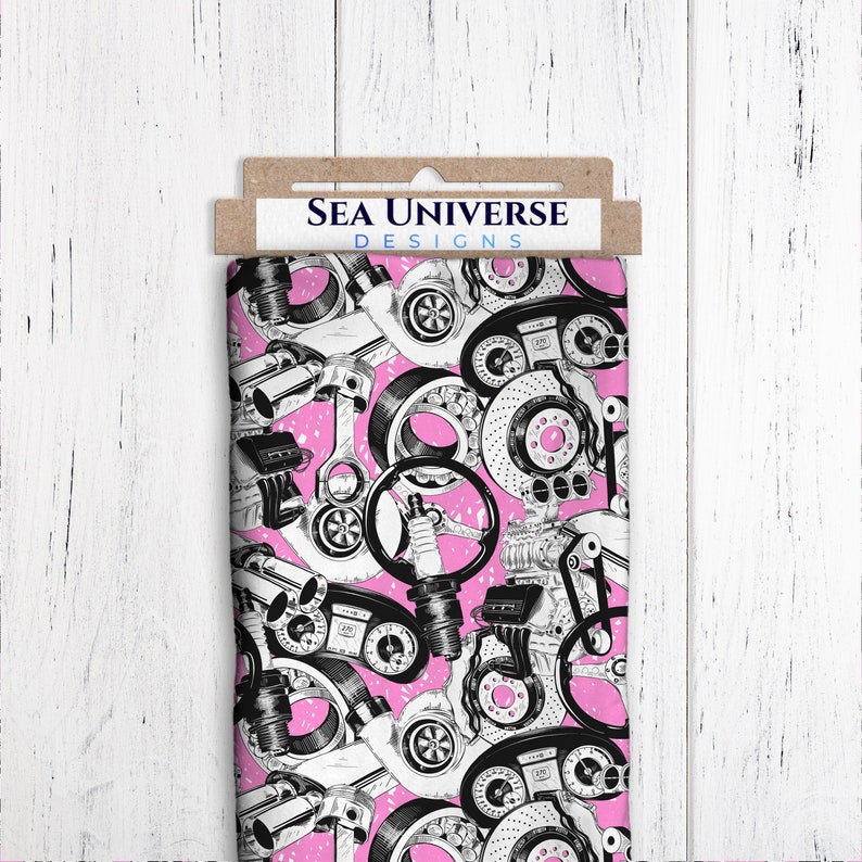 May include: Pink fabric with a black and white print of car engine parts. The fabric has the text "Sea Universe Designs" on a brown tag.