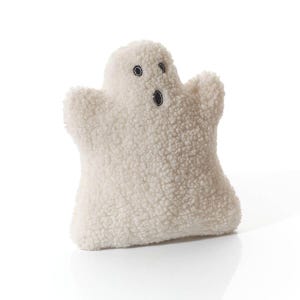 May include: A plush, off-white ghost-shaped pillow with a textured, fuzzy exterior. The ghost has two round black eyes and a black oval mouth. The pillow is designed in a friendly, cartoonish style, perfect for Halloween or spooky decor.