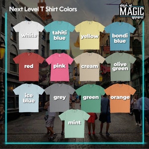 K&ouml;nnte beinhalten: Eine Sammlung von T-Shirts in verschiedenen Farben, darunter Wei&szlig;, Gelb, Blau, Rot, Rosa, Creme, Olivgr&uuml;n, Eisblau, Grau, Gr&uuml;n, Orange und Mint. Die Shirts sind in einem Raster angeordnet und mit ihren jeweiligen Farben beschriftet. Der Text "Next Level T Shirt Colors" befindet sich oben im Bild, und der Text "dash of MAGIC apparel" befindet sich oben rechts im Bild.