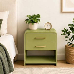 May include: A sage green bedside table with two drawers featuring horizontal gold-toned metal handles and an open storage shelf at the bottom. The unit has rounded corners and a smooth finish, providing a clean and functional storage solution.