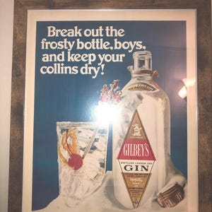 May include: Vintage advertisement for Gilbey's London Dry Gin. The ad features a frosted bottle of gin with a glass of gin and tonic with a cherry garnish. The text reads "Break out the frosty bottle, boys, and keep your collins dry!"