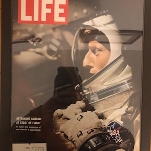 May include: A vintage LIFE magazine cover featuring astronaut Gordon Cooper in a white spacesuit, with the text "ASTRONAUT CONRAD AT START OF FLIGHT" and "SEPTEMBER 3, 1965 - 35¢".